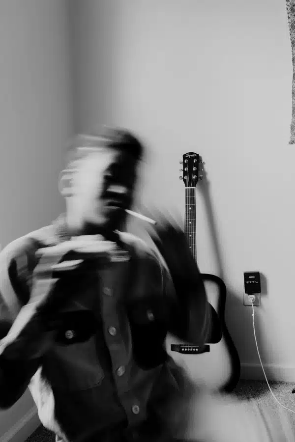 blurry photo of man seemingly high and smoking smothing.