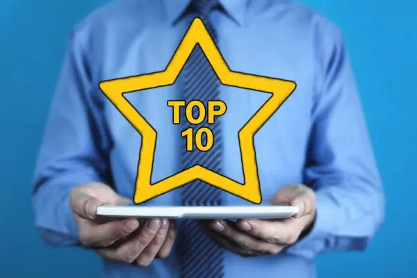 person holding a tablet with a computer graphic yellow star and text reading TOP 10 above it.