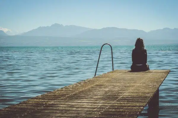 person sitting at end of dock.