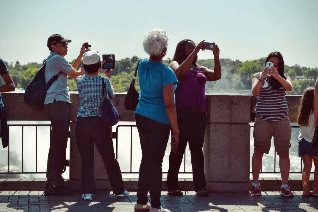 tourists taking pictures on a bridge.