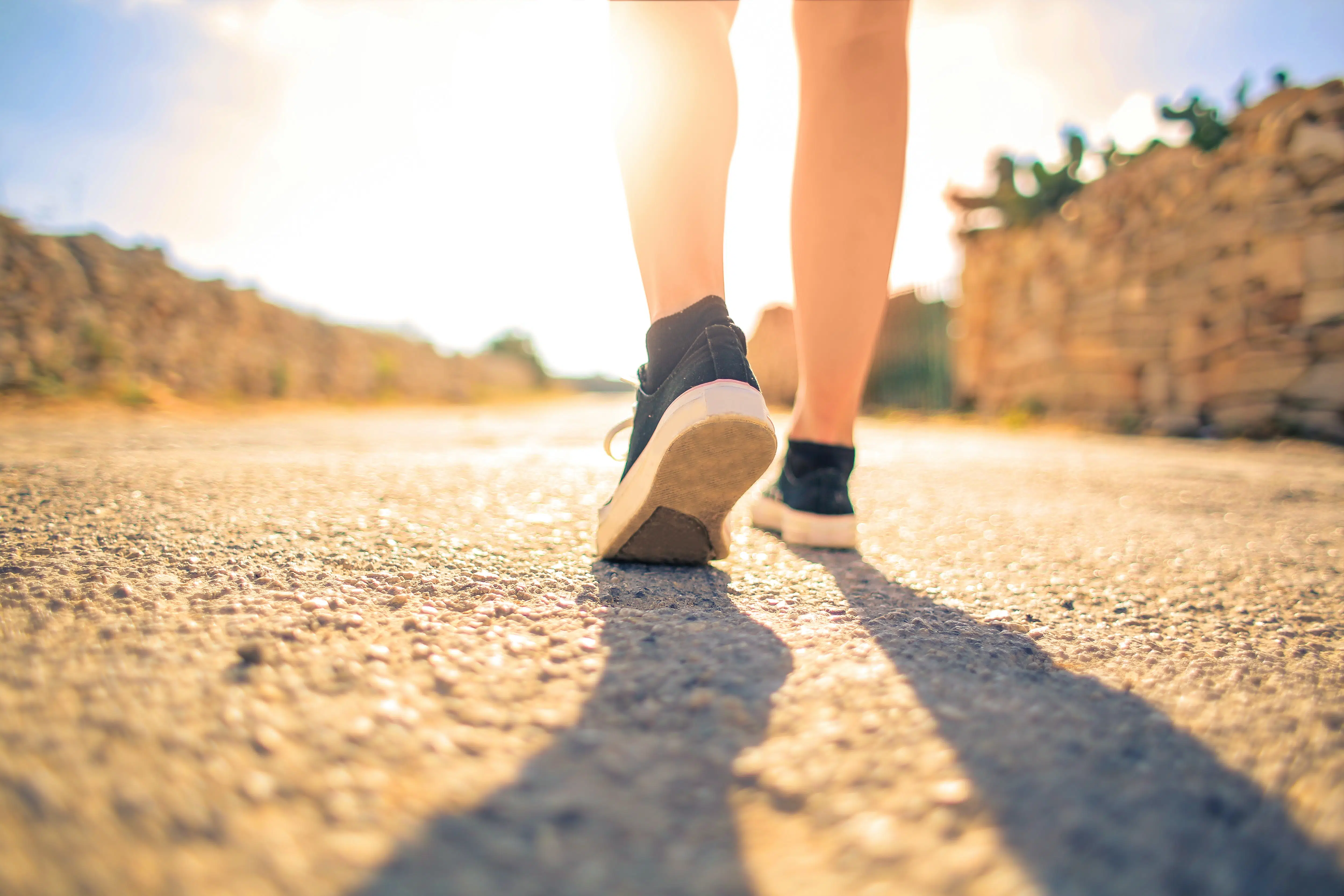 view of legs walking on road.
