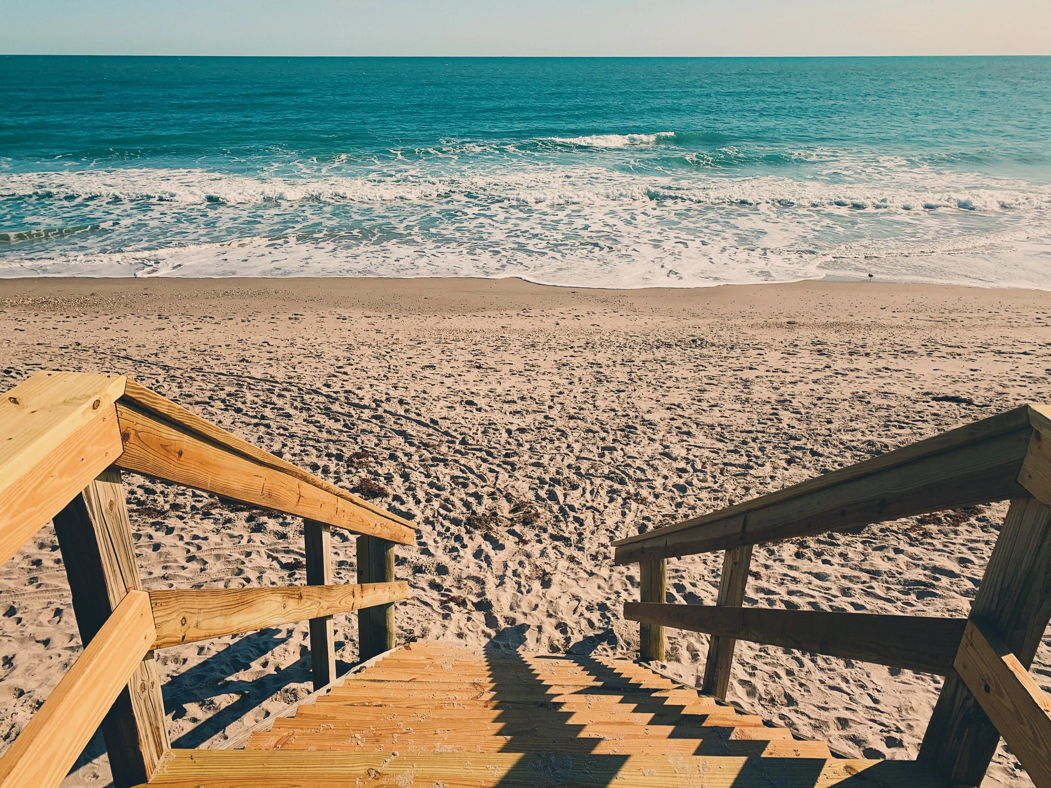 view looking down stairs onto the beach.