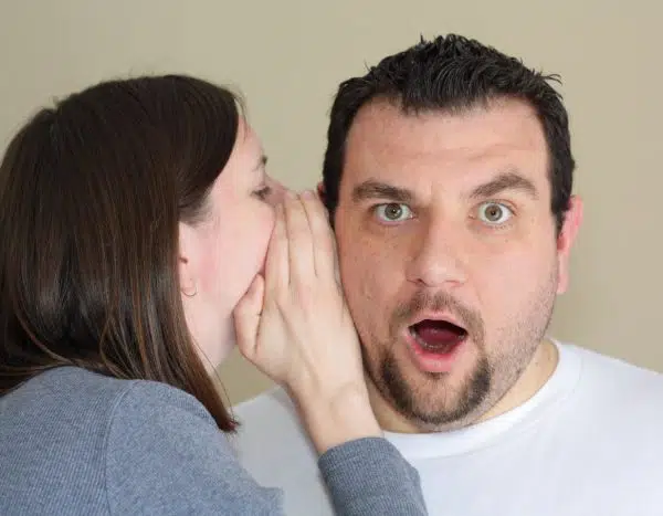 woman whispering into mans ear