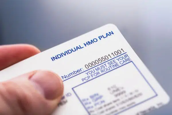 fingers holding insurance card.