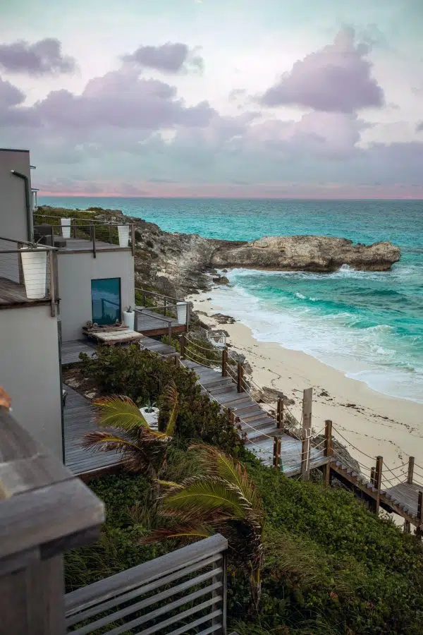 cliffside home overlooking bright blue waters. 