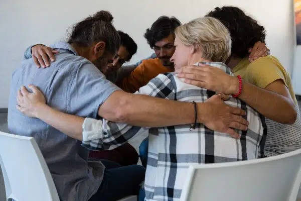group therapy with arms around each other.
