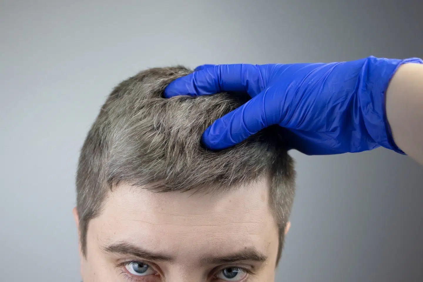 gloved hand in mans hair