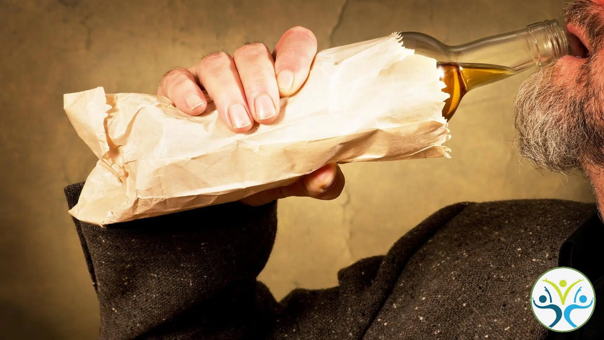 side view of a man'd hand holding a bottle of alcohol in a brown paper bag up to his mouth.