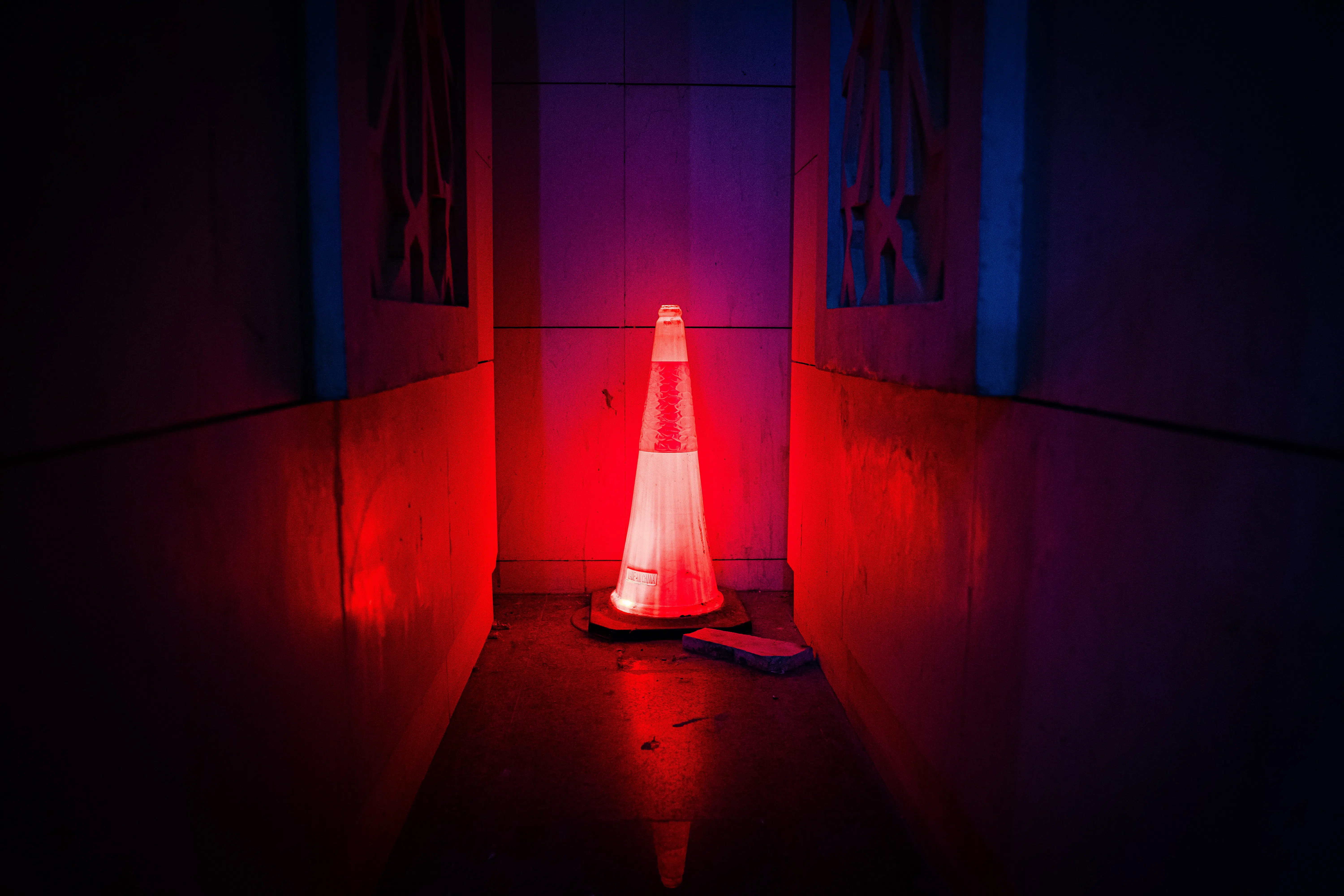 dark end of a hallway with a red cone that is lit.
