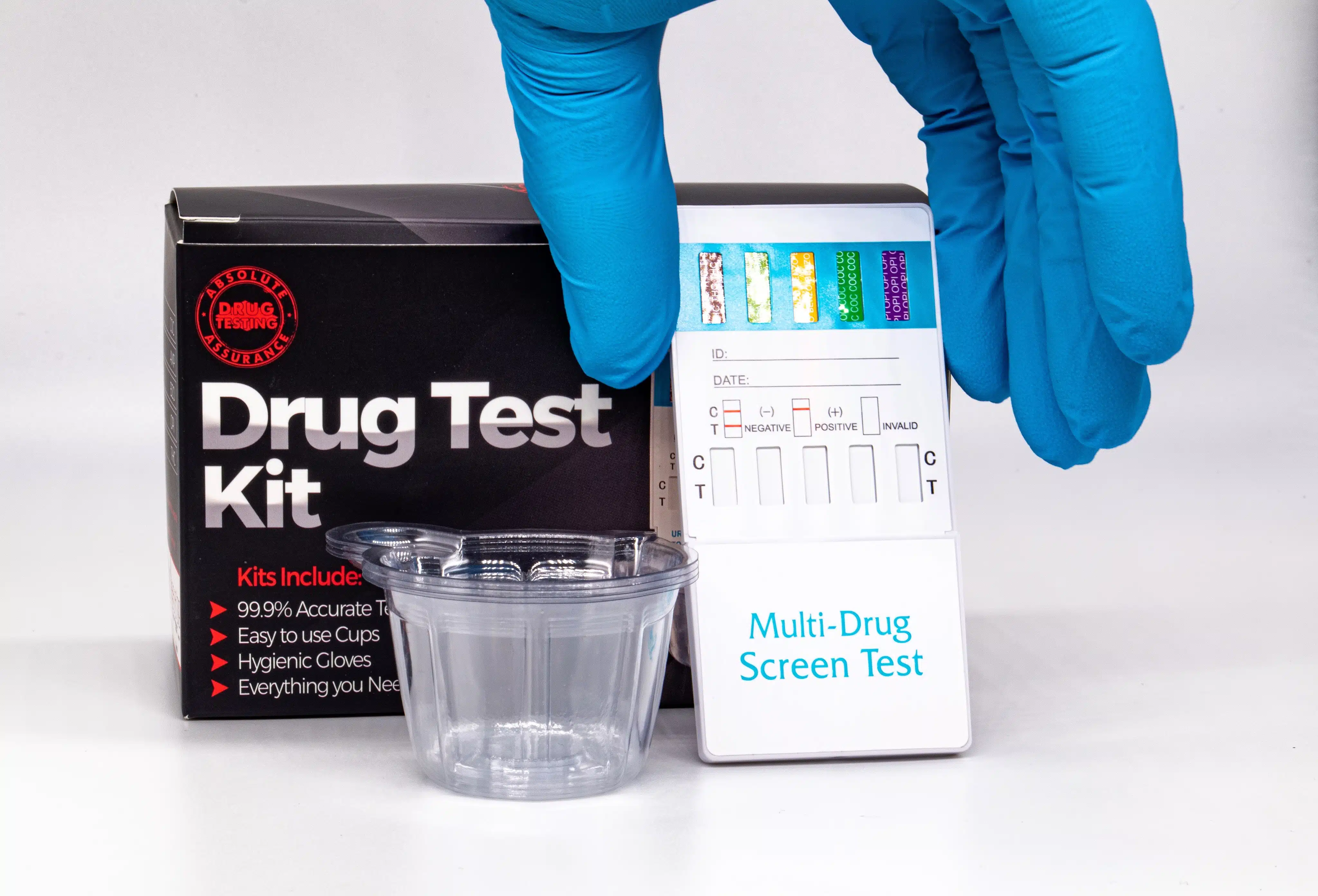 gloved hand holding a drug test kit.