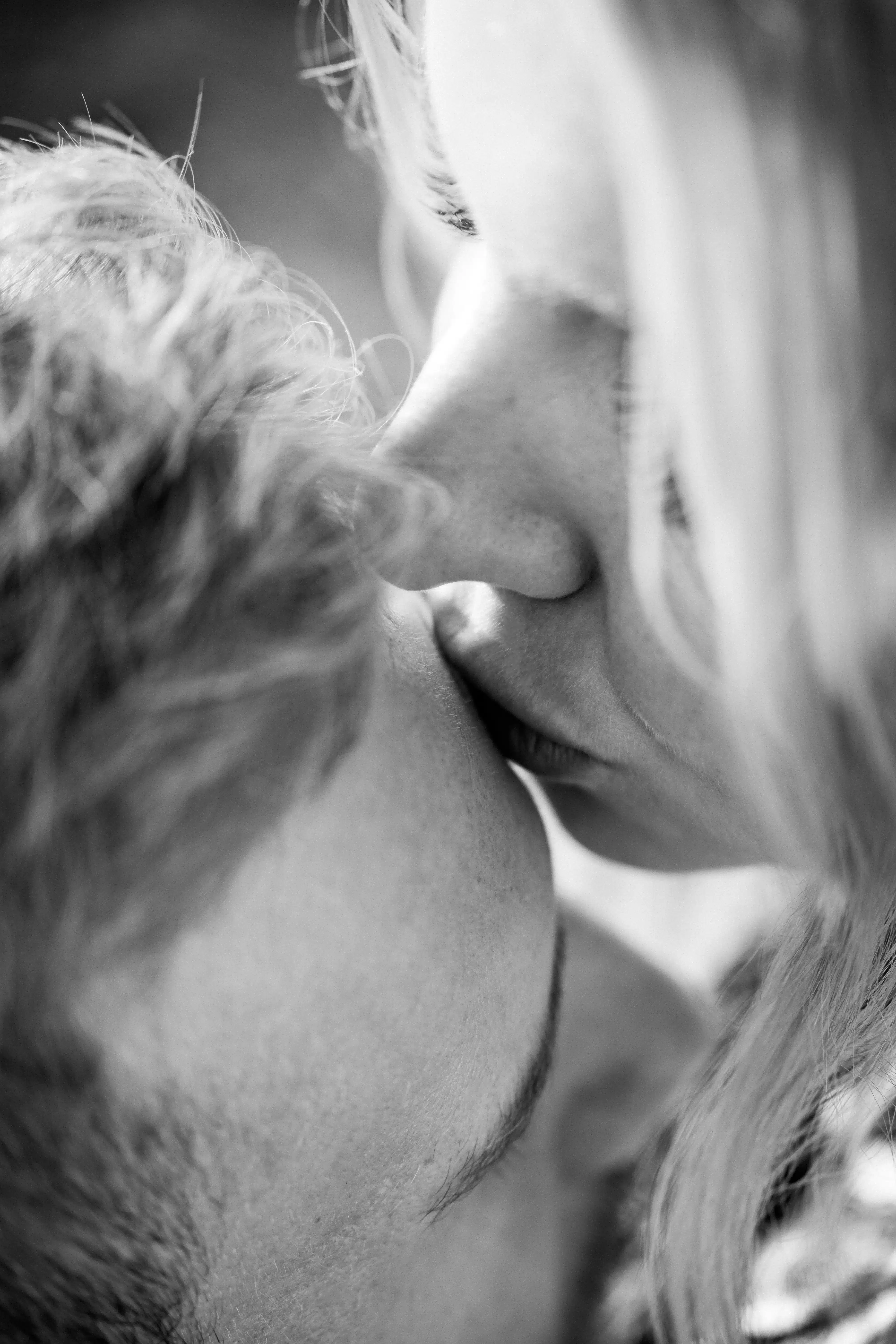 close up of woman kissing man on forehead.