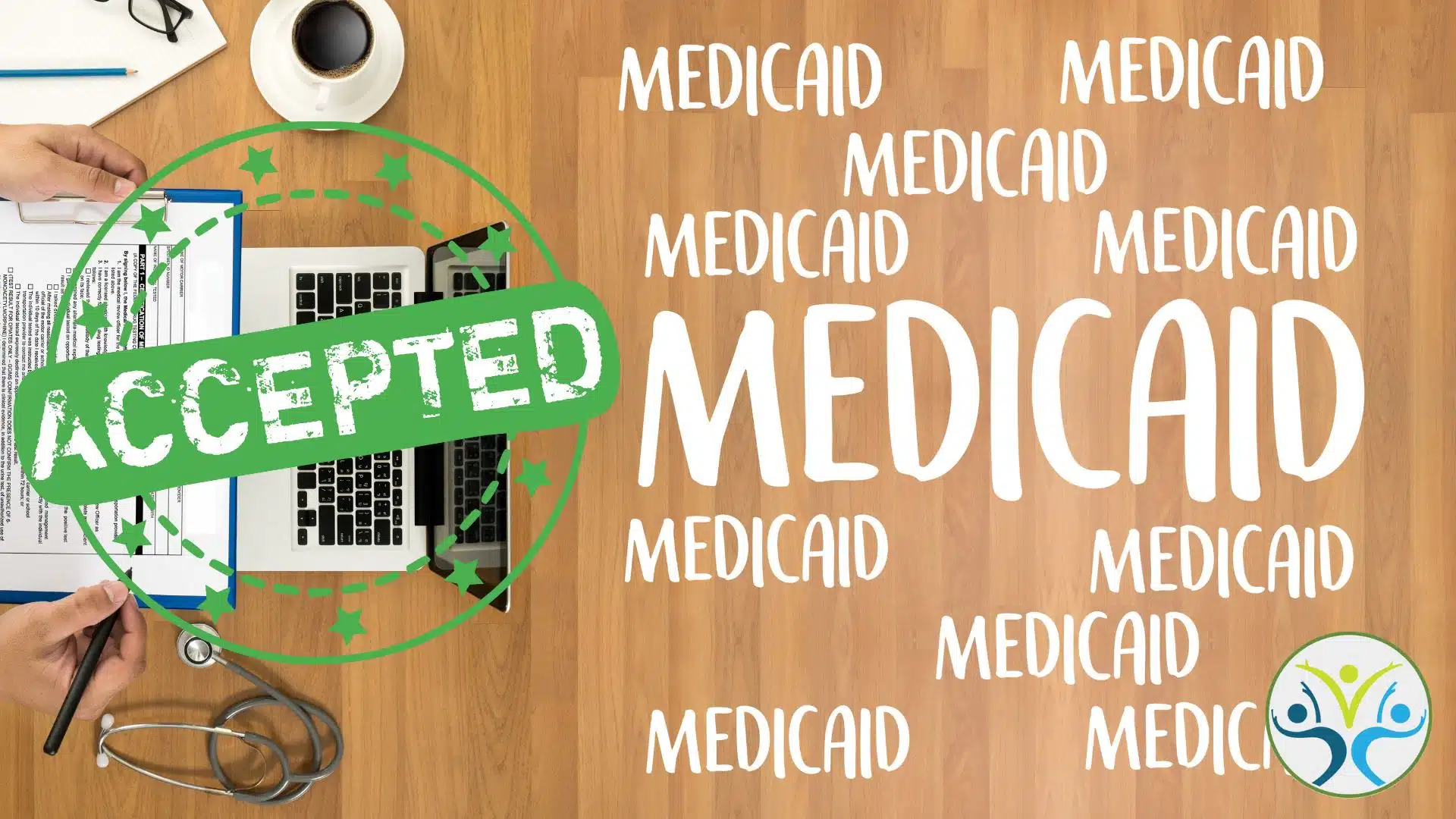 desk with "medicai" word art, a laptop, mug, and an "approved" stamp.